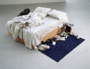 Un lit défait, entouré de mégots, de bouteilles vides et d'autres détritus personnels illustrent la difficulté de changer